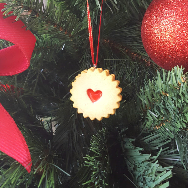 Decorative ornament with a red heart on a Christmas tree.