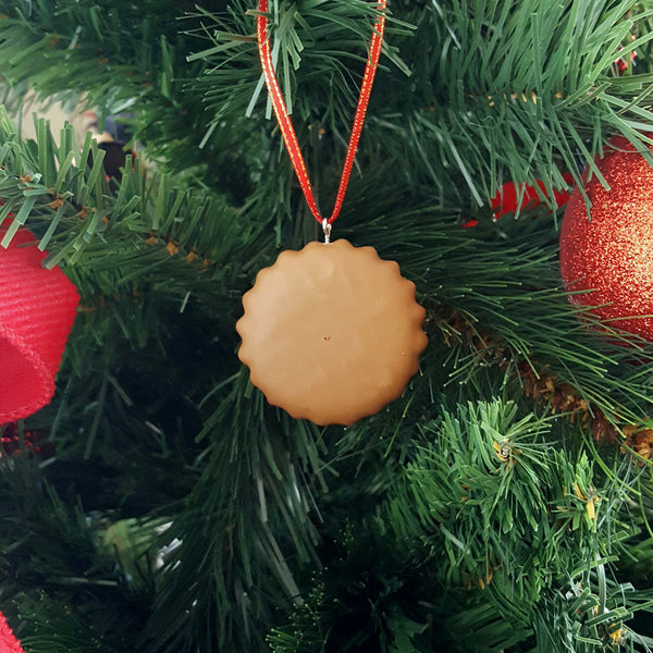Round chocolate toffee pop ornament on a Christmas tree with red ribbon

