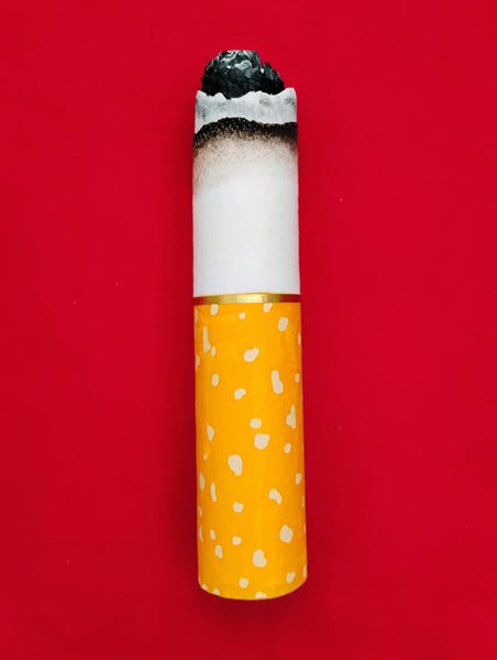 Cigarette with a yellow filter on a red background