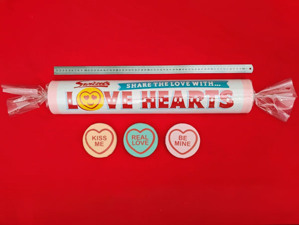 Swizzles Love Hearts candy roll with three heart-shaped buttons on a red background