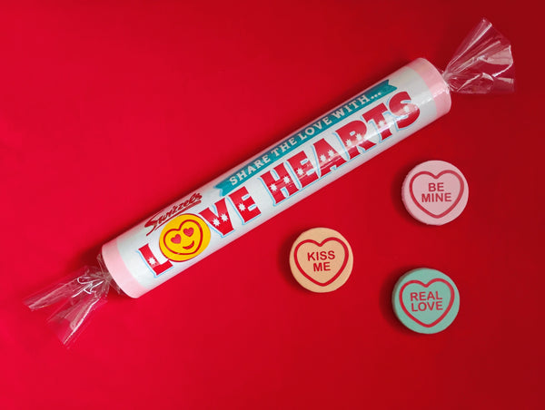 Love Hearts candy roll with heart-shaped candies on a red background