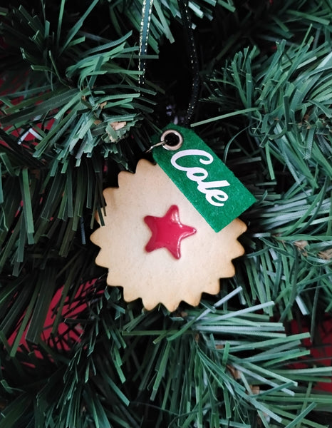 Decorative cookie ornament with a red star on a Christmas tree