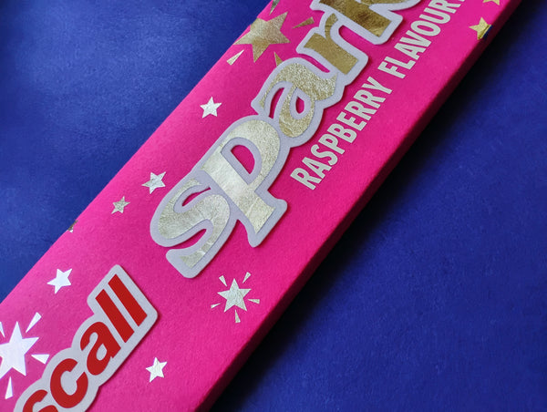 Pink candy Sparkles wrapper with  'Raspberry Flavour' text on a blue background