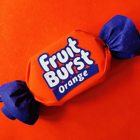 Fruit Burst Orange candy wrapper on an orange background