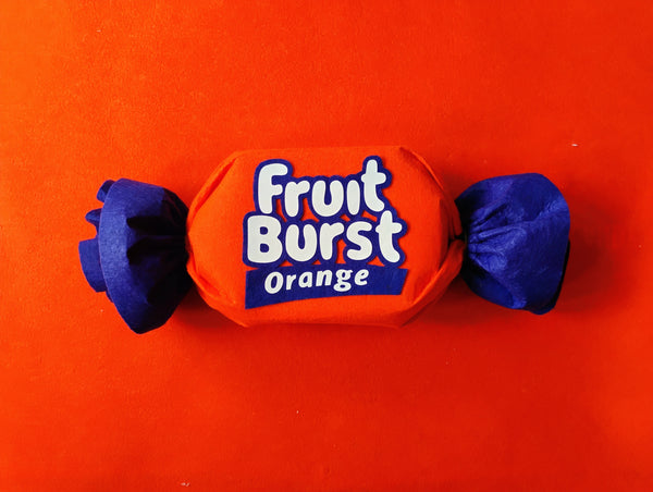 Orange and blue Fruit Burst candy on a red background