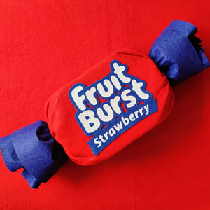 Red and blue Fruit Burst strawberry candy on a red background