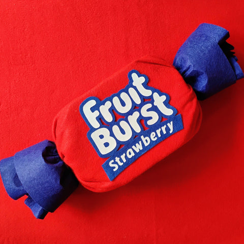 Red and blue Fruit Burst strawberry candy on a red background